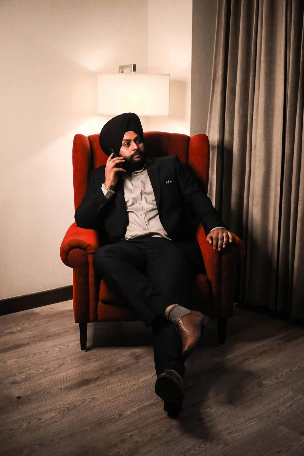 Jovanpreet seated in a red armchair